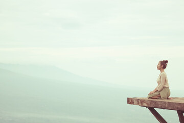 Meditation in the mountains, a girl sits on a platform in the mountains, Bali Indonesia landscape