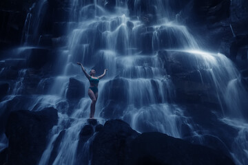 Beautiful adult girl in a natural waterfall incredible Bali landscape