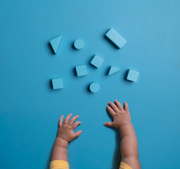 The child plays with wooden blue blocks. Family vacation with children for the holidays,top view