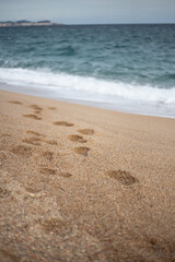 Footsteps on a sandy beach with quiet waters in the Mediterranean Sea