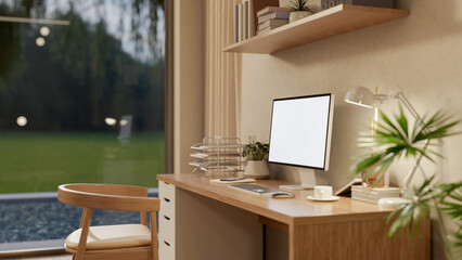 White screen computer on wooden study desk under hanging display shelf and a chair in a cosy room.