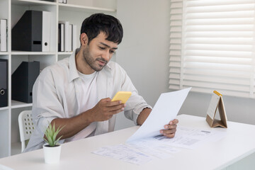 business man use phone to scan barcode or QR codes to pay credit card bill after receiving document invoice online. payment, receive, paying electricity, digital payments without money, technology.