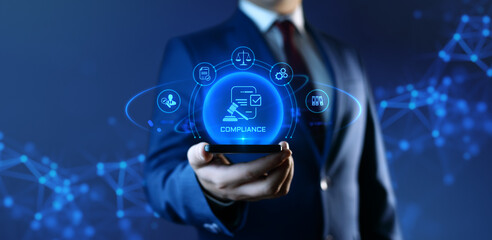 Businessman holding smartphone with compliance icons on screen - business and regulations concept