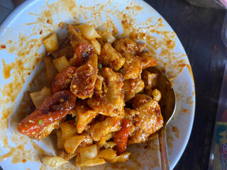 White bowl of spicy tofu with a spoon.