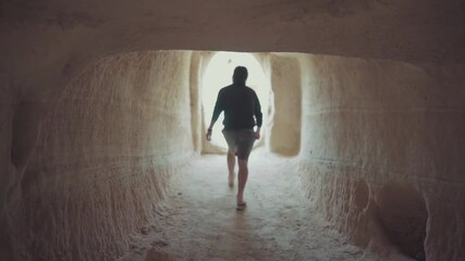 Silhouette of a person walking in a tunnel walking leisurely