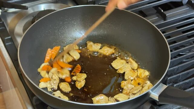 A frying pan with sizzling garlic and chili, showcasing home cooking, Asian cuisine, and culinary techniques