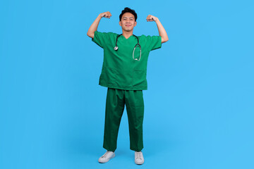 Naklejka premium Portrait of Medical Staff in Scrubs and Stethoscope Flexing Arm Muscle and Feeling Proud