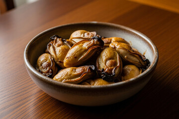 A rustic-style food photo of Rocky Mountain Oysters on a plate/bowl on a wooden dining table.