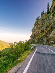 transfagarasan road winding near steep slope. great outdoors of fagaras mountain ridge of romania in summer. popular travel destination of europe on high altitude in morning light