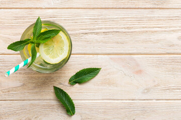 Caipirinha, Mojito cocktail, vodka or soda drink with lime, mint and straw on table background. Refreshing beverage with mint and lime in glass top view flat lay