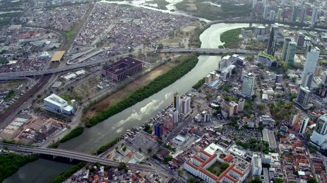Aerial daytime view over Recife Pernambuco showing the Justice Forum near stilt houses or palafitas along the river highlighting urban poverty and social inequality within the metropolis.