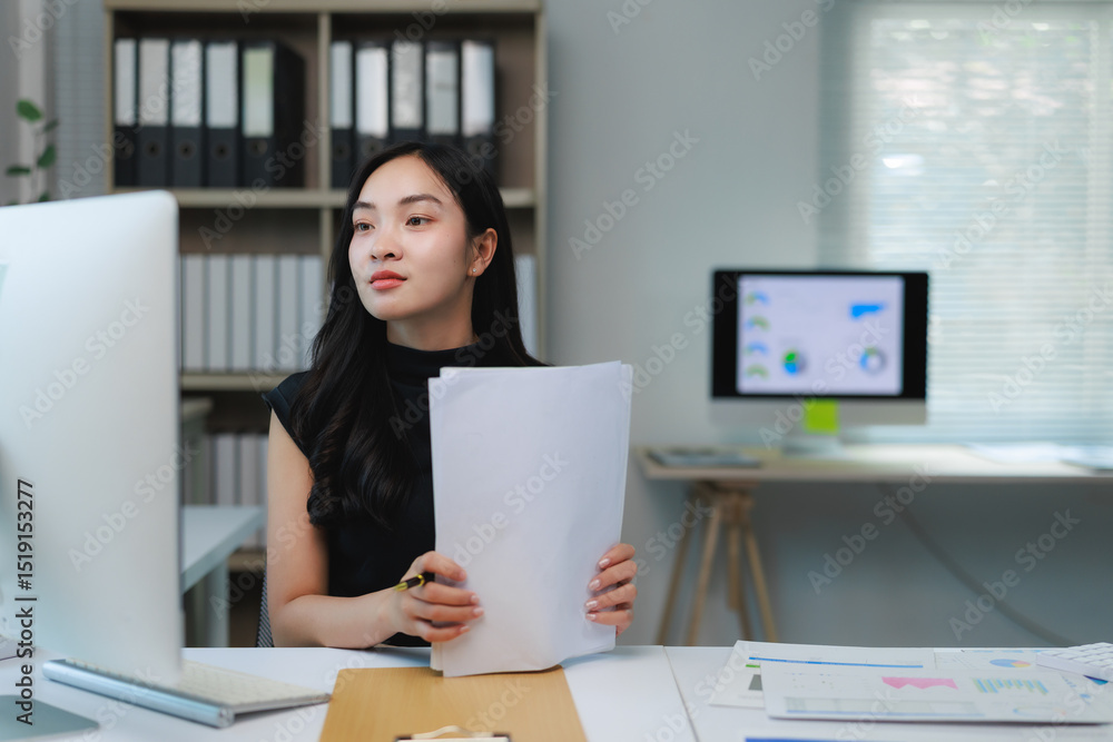 Poster young office worker analyzing documents and working on a computer
