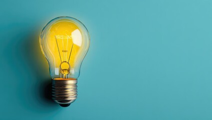 Glowing lightbulb on a light blue background, illuminating ideas and innovation.  Plenty of copy space to the right
