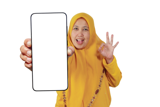 Cheerful hijabi woman shows smartphone screen and makes OK sign with happy expression