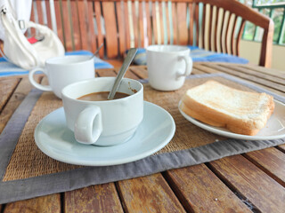 030625035 a cup of coffee and a sandwich on a table