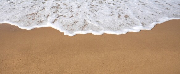 Waves crashing onto shore and sandy beaches in summer