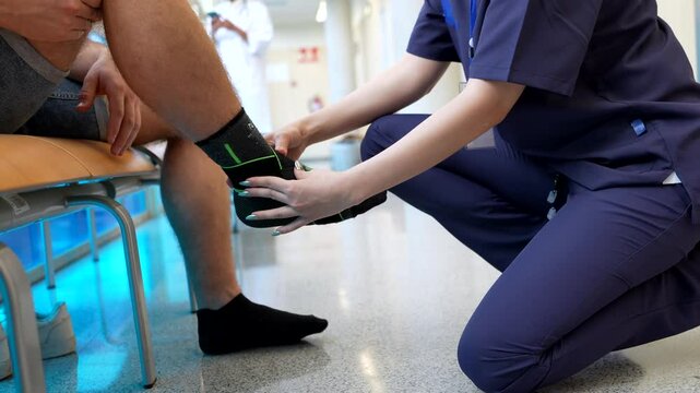Nurse applying orthopedic ankle brace on patient's foot - Powered by Adobe