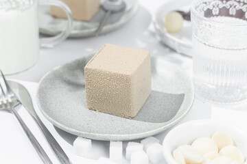 Mousse cake . Beautiful cake covered with Velour  in a plate on the table. Confectionery, coffee shop