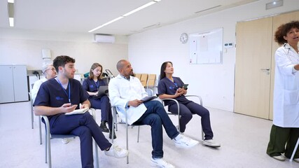 Medical team attending a conference led by female doctor - Powered by Adobe