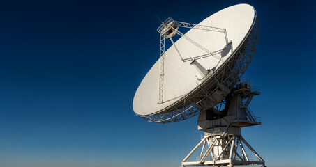 Massive Radio Telescope Dish Reaching Toward Clear Blue Sky in Scientific Research Facility