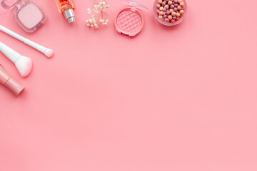 Makeup cosmetic products in brown pink shades - powder, blush and lipstick with perfume, top view