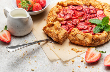 Delicious homemade strawberry galette with almond petals baking on parchment paper