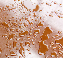 A brown surface with many small drops of water on it