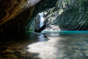 A large cave with a waterfall and a small stream