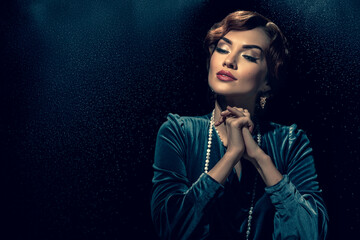Romantic beautiful lady with retro wave hairstyle posing on dark background with dust particles....