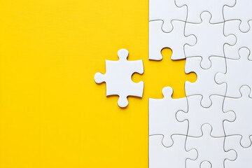 Obraz premium Missing piece white jigsaw puzzle on yellow background