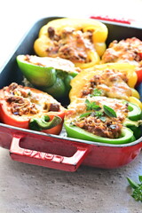 Stuffed peppers with meat, cheese and vegetables in a baking dish
