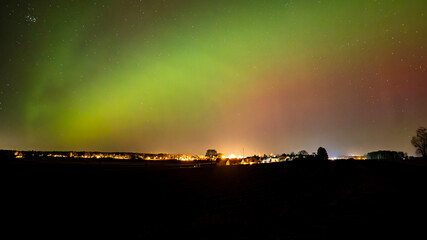 Northern lights dancing over country landscape 
