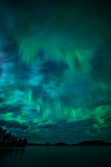 Moon light lake with a dancing northern lights in Farnebofjarden national park in north of Sweden.