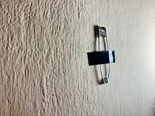 Safety pins duct-taped to the wall