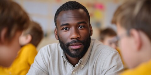 African male teacher engaging with students in classroom setting