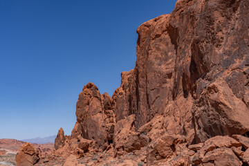 Fototapeta premium Fire Wave Trail, red Aztec Sandstone outcrops, Early Jurassic geological formation of primarily eolian sand. Valley of Fire State Park, Clark County, Nevada geology. Weathering. Desert varnish