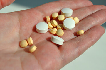 Pills in hand. Close-up of a palm holding medications. The concept of health, drugs and medicine