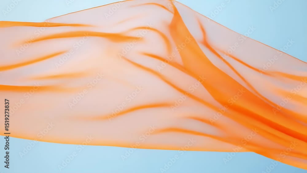 Aufkleber 明るい青色の背景に舞い上がる透明なオレンジ色の布地のクローズアップ、滑らかな質感と優雅なドレープを示しています