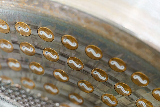 Macaroni extrusion dies showcasing eflon-coated plates for efficient pasta production in a manufacturing facility