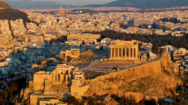 Aerial view of the Acropolis of Athens, Greece, with Parthenon Temple and Temple of the Athena Nike during golden sunset time