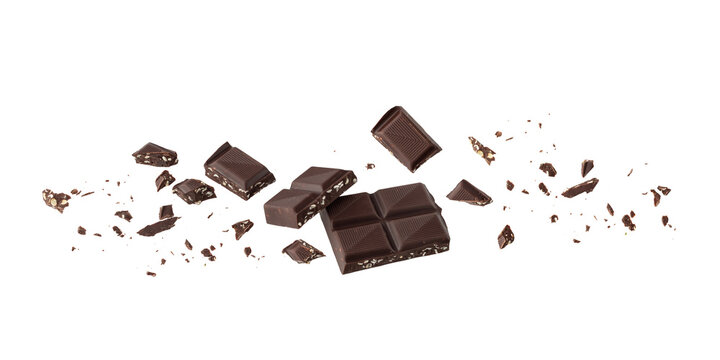 Broken organic dark chocolate bar infused crushed seeds with crumbs flying falling isolated on white background. Vegan bitter chocolate pieces.