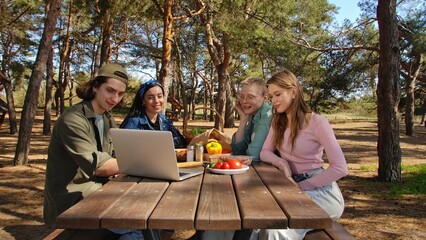 Friends Enjoying a Picnic in the Park While Video Calling