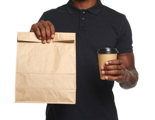 A man holds a paper bag in one hand and a takeaway coffee cup in the other, dressed in a black polo shirt.
