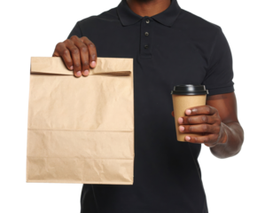 A man holds a paper bag in one hand and a takeaway coffee cup in the other, dressed in a black polo shirt.