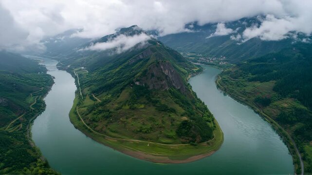 Aerial view of river bend around mountain peak
