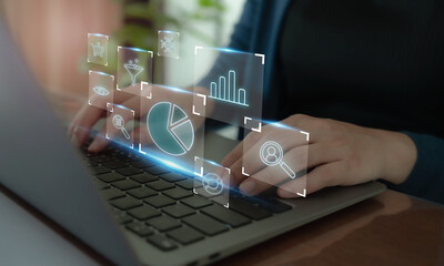 Digital marketing analytics concept. Typing on a laptop with virtual data analytics icons, including charts, graphs and search tools, digital marketing, data analysis and business intelligence.