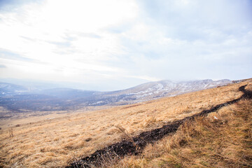 Expansive golden grassland meadows roll across mountain landscape  under beautiful dramatic cloudy skies, Rtanj mountain, Serbia.
