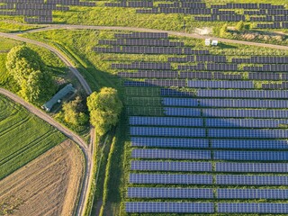 Aerial view of a solar farm with rows of panels.