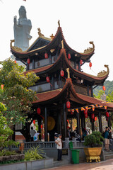 Obraz premium A group stands in front of a pagoda with a statue behind them