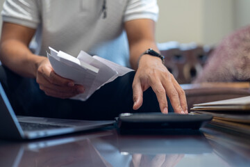 Businessman calculating tax with laptop, calculator, and financial documents tax payment planning,...